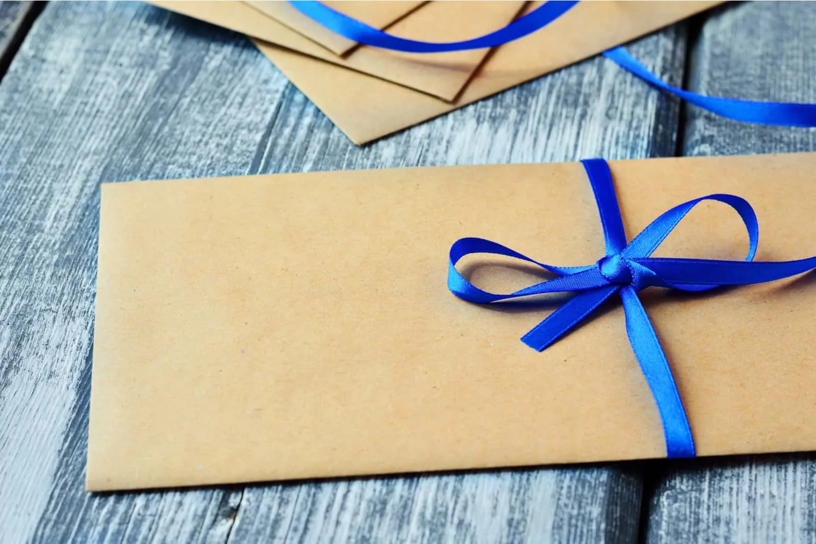 Kraft-Umschlag mit blauem Band in einer Schleife gebunden