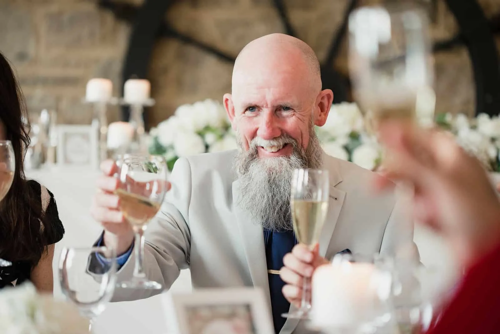 Älterer Mann hebt sein Glas bei der Hochzeit seiner Tochter zu einem Toast