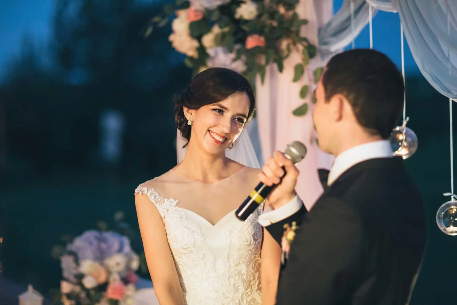 Der Bräutigam hält ein Mikrofon und spricht mit seiner Braut