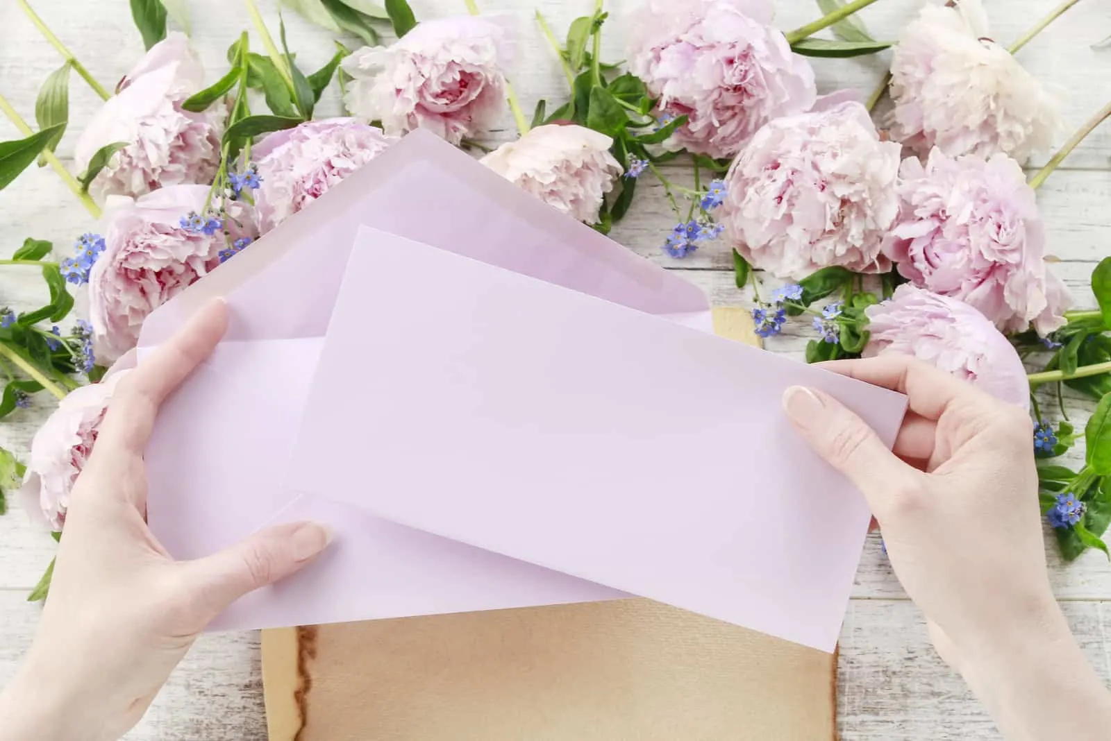Frau, die rosa Blatt Papier und Umschlag hält