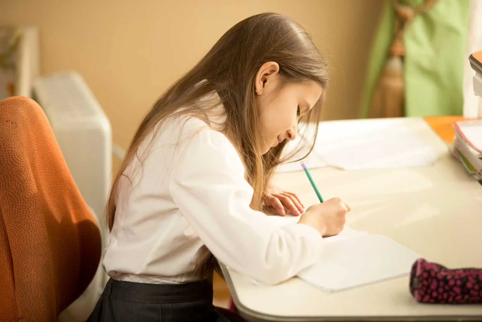 Mädchen, das im Notizbuch mit Bleistift an ihrem Schlafzimmer schreibt
