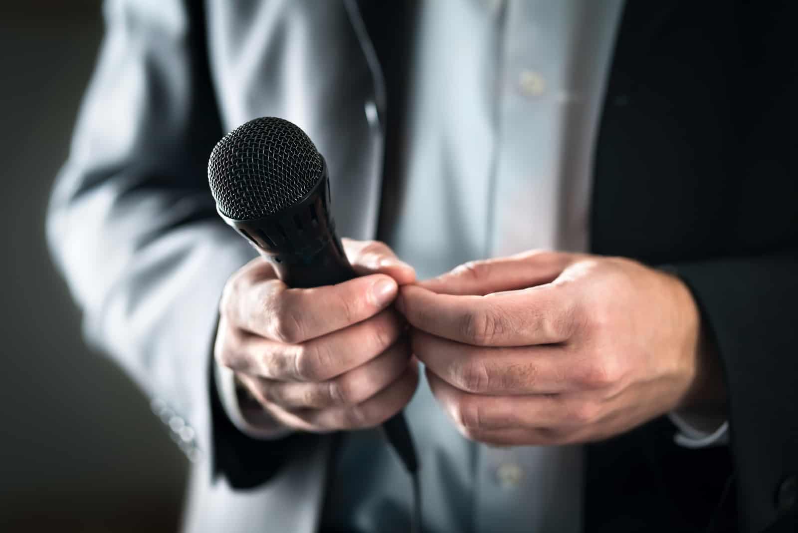 Nervöser und schüchterner Redner mit Mikrofon