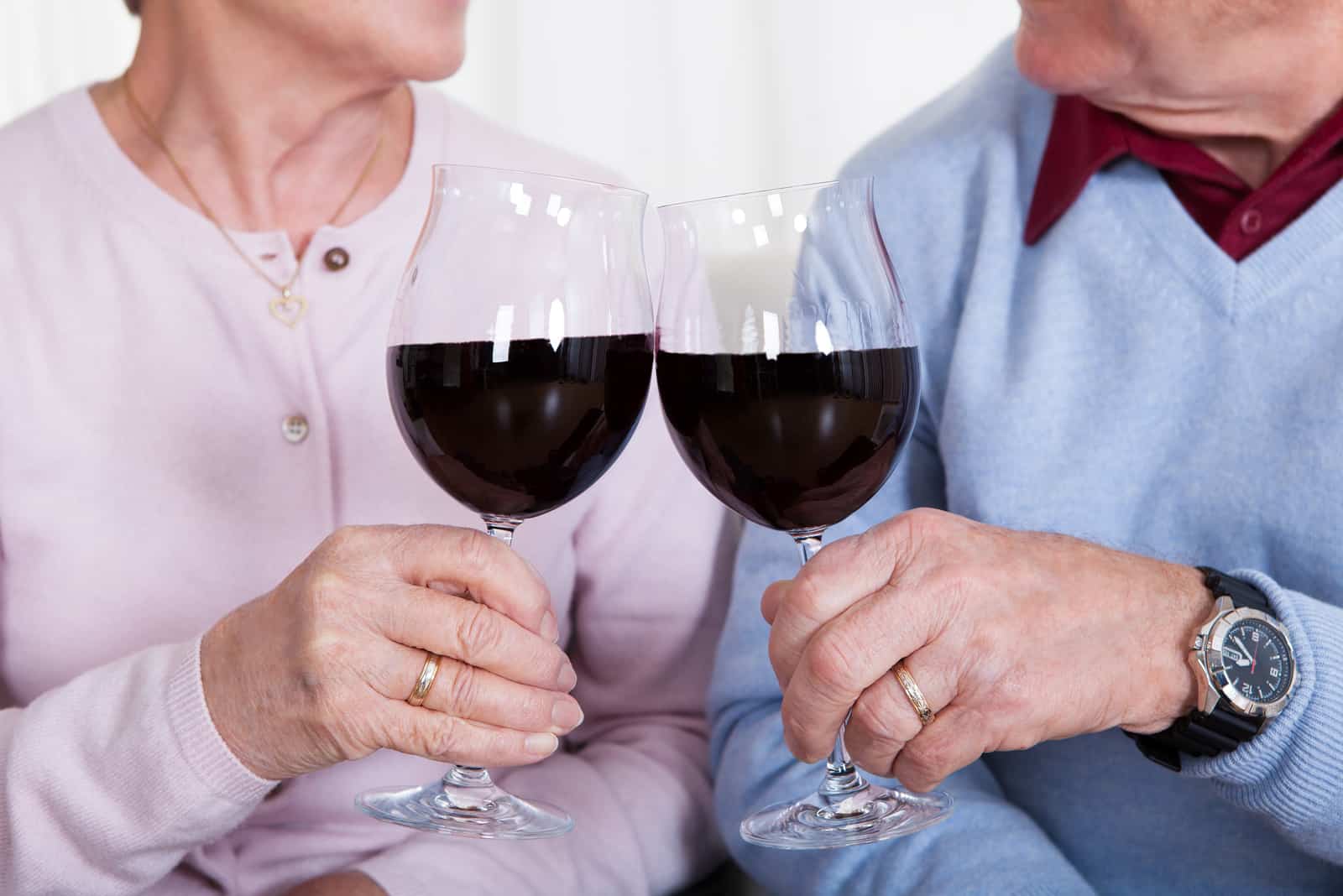 Älteres Paar, das Glas Wein röstet