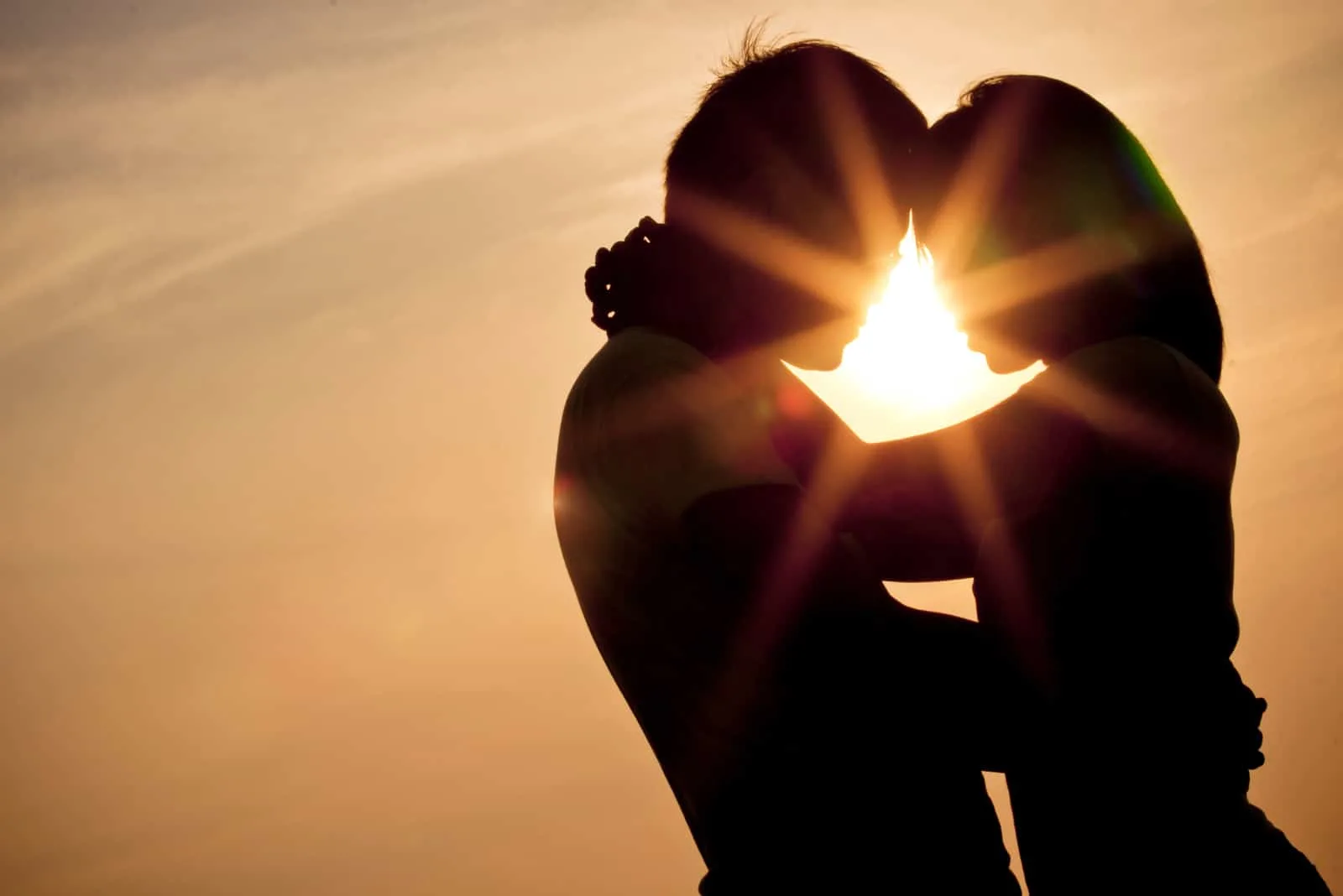 Bei Sonnenuntergang umarmt sich ein liebendes Paar