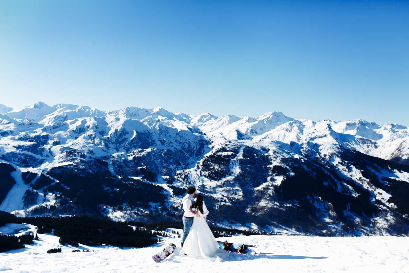 Braut und Bräutigam in Liebe küssen auf dem Hintergrund der Alpen Courchevel