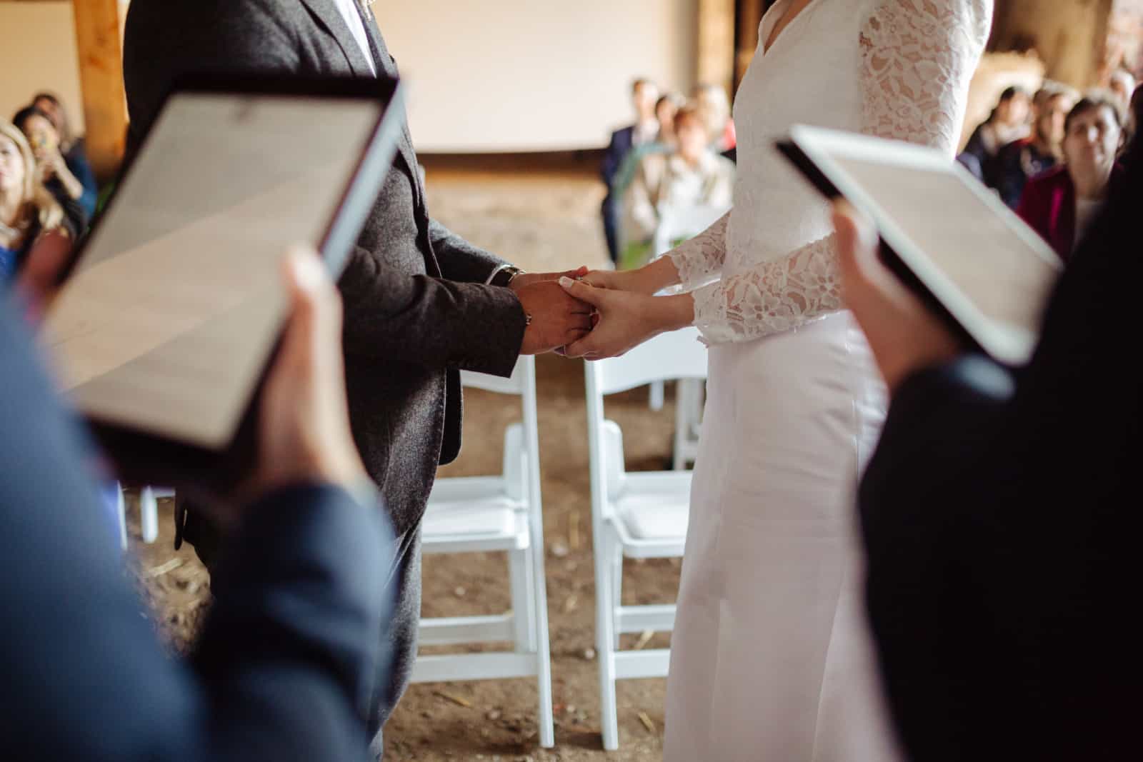Braut und Bräutigam halten sich bei der Hochzeit an den Händen