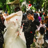 Hochzeitspaar nach der Heirat, während die Gäste traditionellen Reis werfen