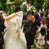 Hochzeitspaar nach der Heirat, während die Gäste traditionellen Reis werfen