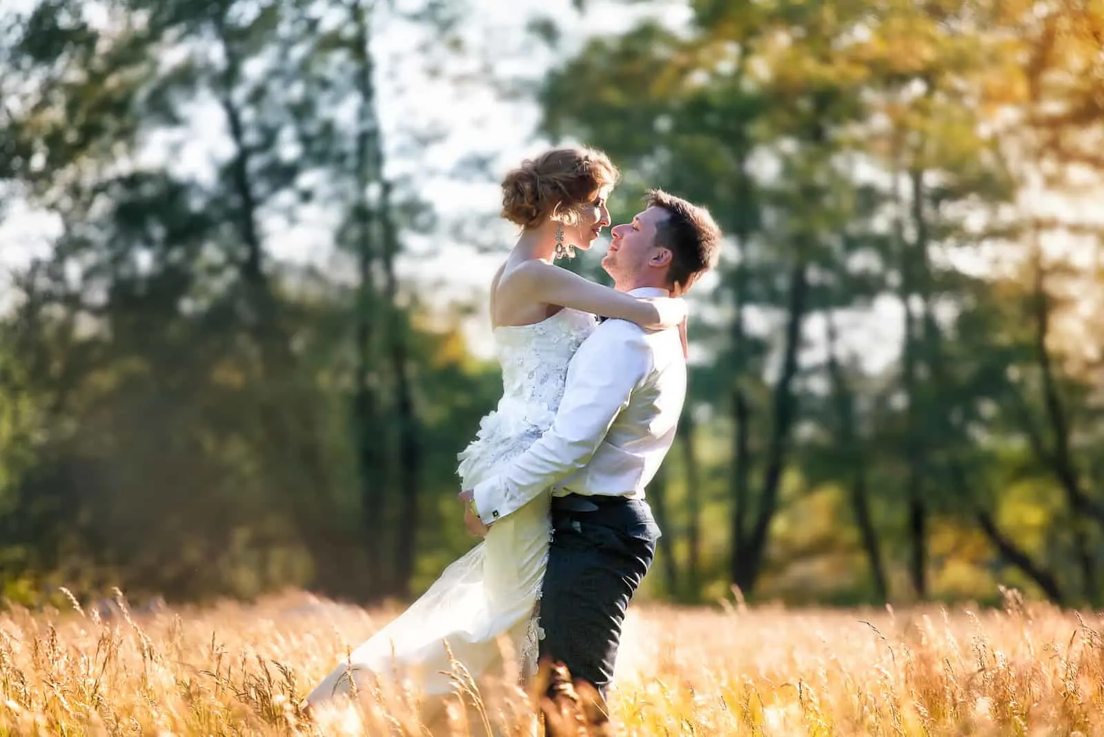 Ein junges Paar umarmt und küsst sich auf einem Weizenfeld
