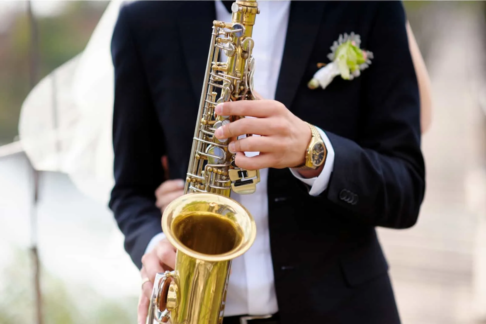 Hände des Bräutigams spielen auf Saxophon