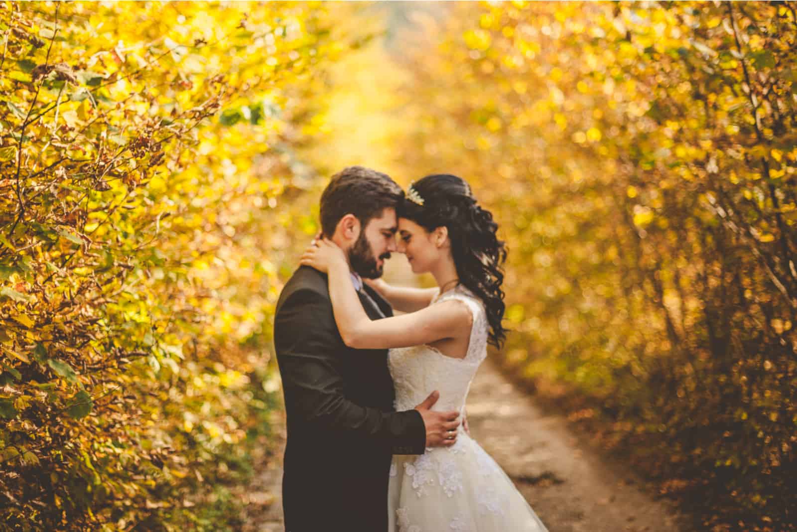 Hochzeit Herbst. Braut und Bräutigam gehen im gelben Herbstwald