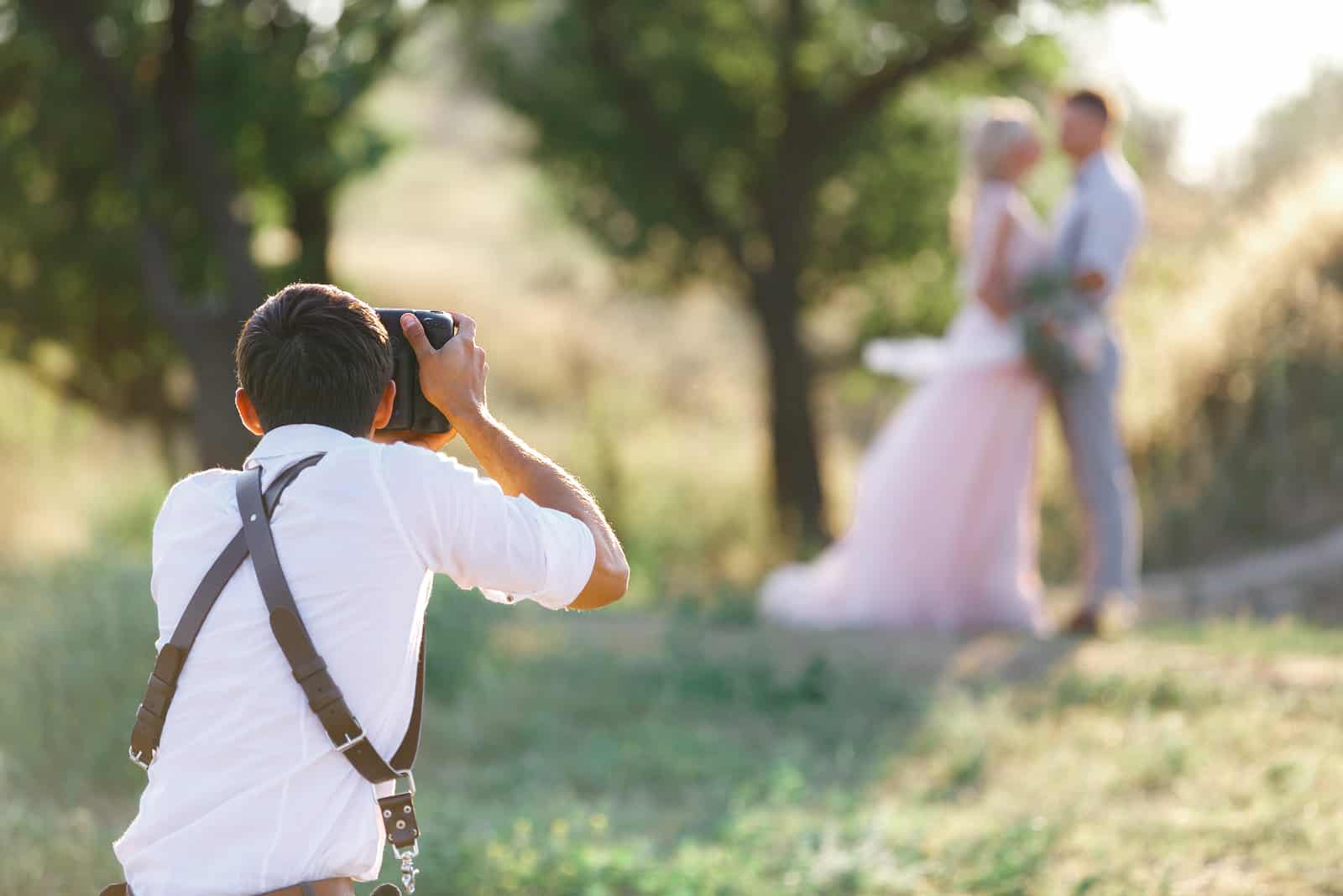 Hochzeitsfotograf fotografiert Braut und Bräutigam in der Natur