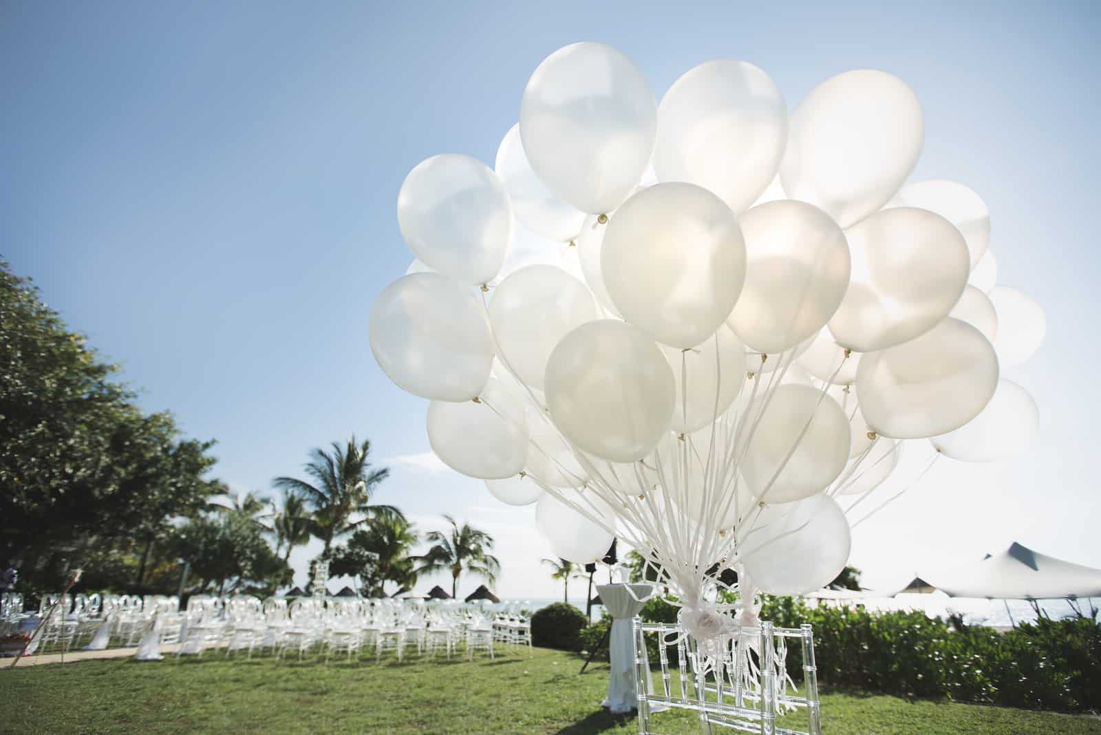 Romantische Hochzeitszeremonie am Strand mit vielen weißen Luftballons