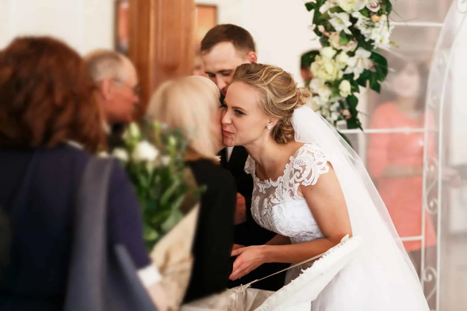 Schöne stilvolle Braut und Bräutigam unter den Hochzeitsgrüßen von den Gästen