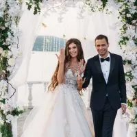 Bräutigam und Braut am Hochzeitstag Zeremonie mit Bogen auf Hintergrund
