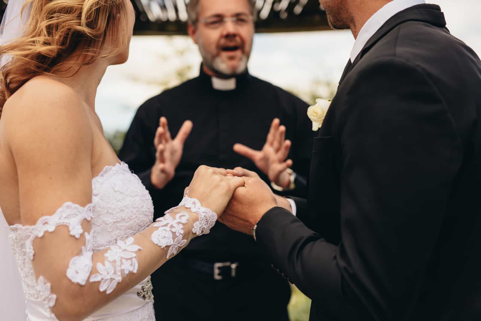 ein Paar Händchen haltend bei einer Hochzeit