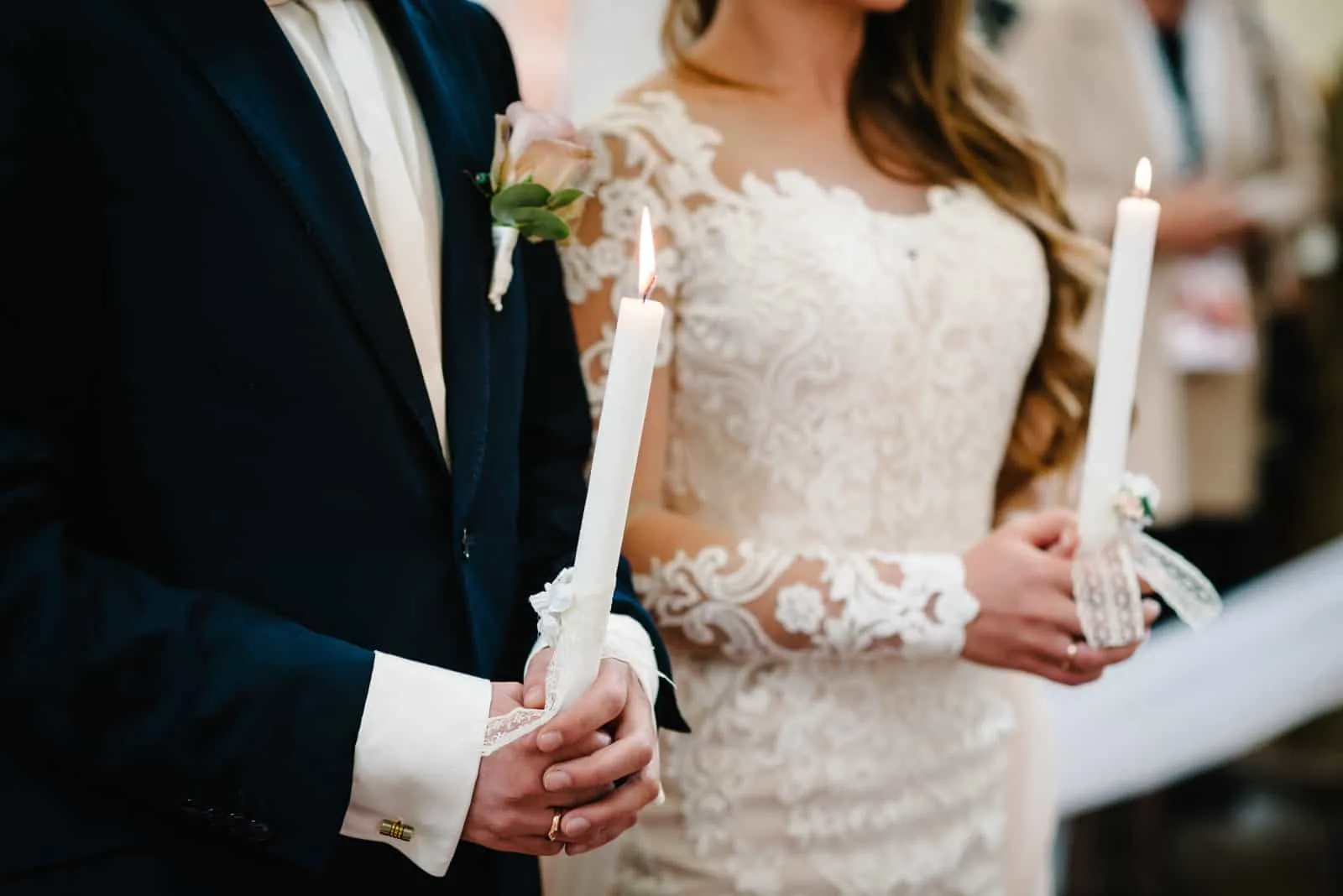 ein verheiratetes Paar, das Kerzen in den Händen hält