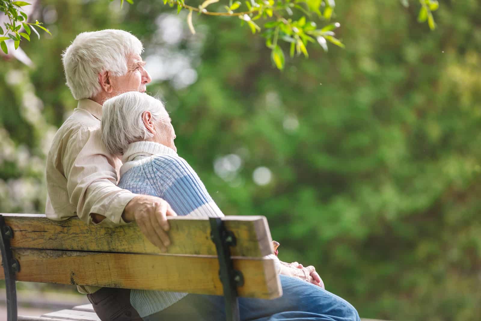 Älteres Paar, das auf einer Bank im Park ruht