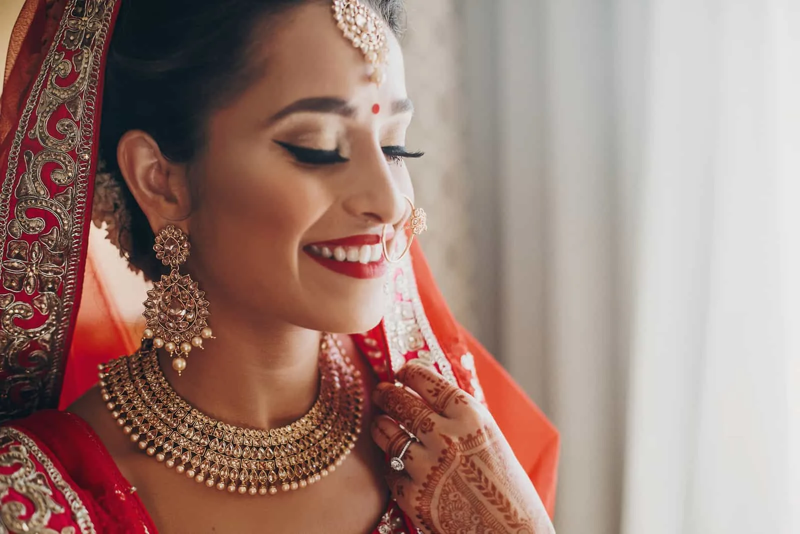 Atemberaubende indische Braut gekleidet in hinduistischen roten traditionellen Hochzeitskleidern