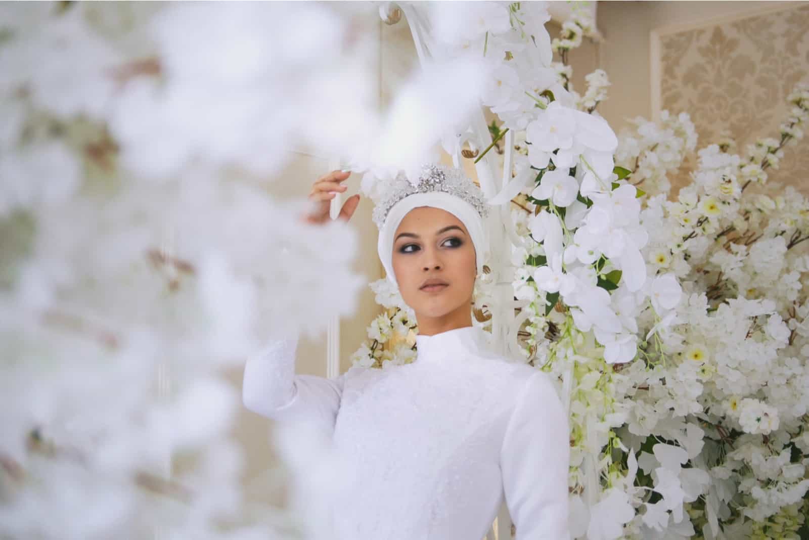 Braut mit Tiara im Hochzeitskleid in weißen Blumen