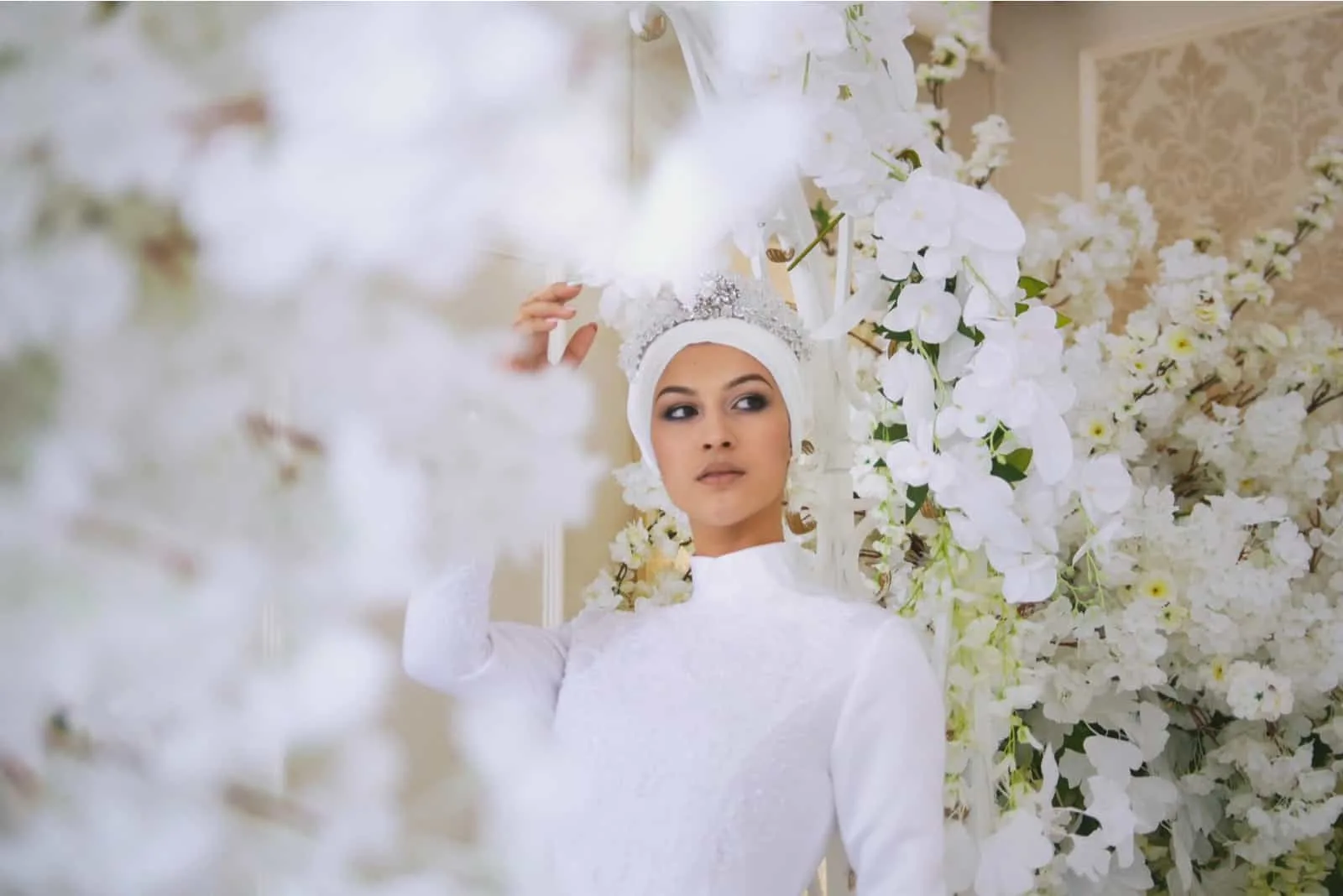 Braut mit Tiara im Hochzeitskleid in weißen Blumen