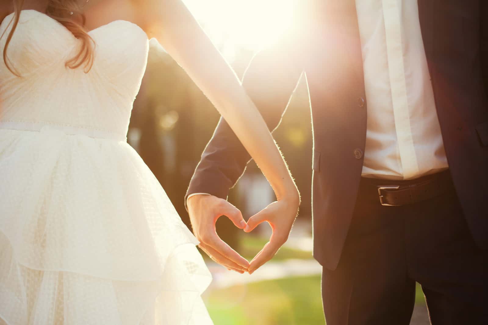 Braut und Bräutigam Händchen haltend in Form des Herzens