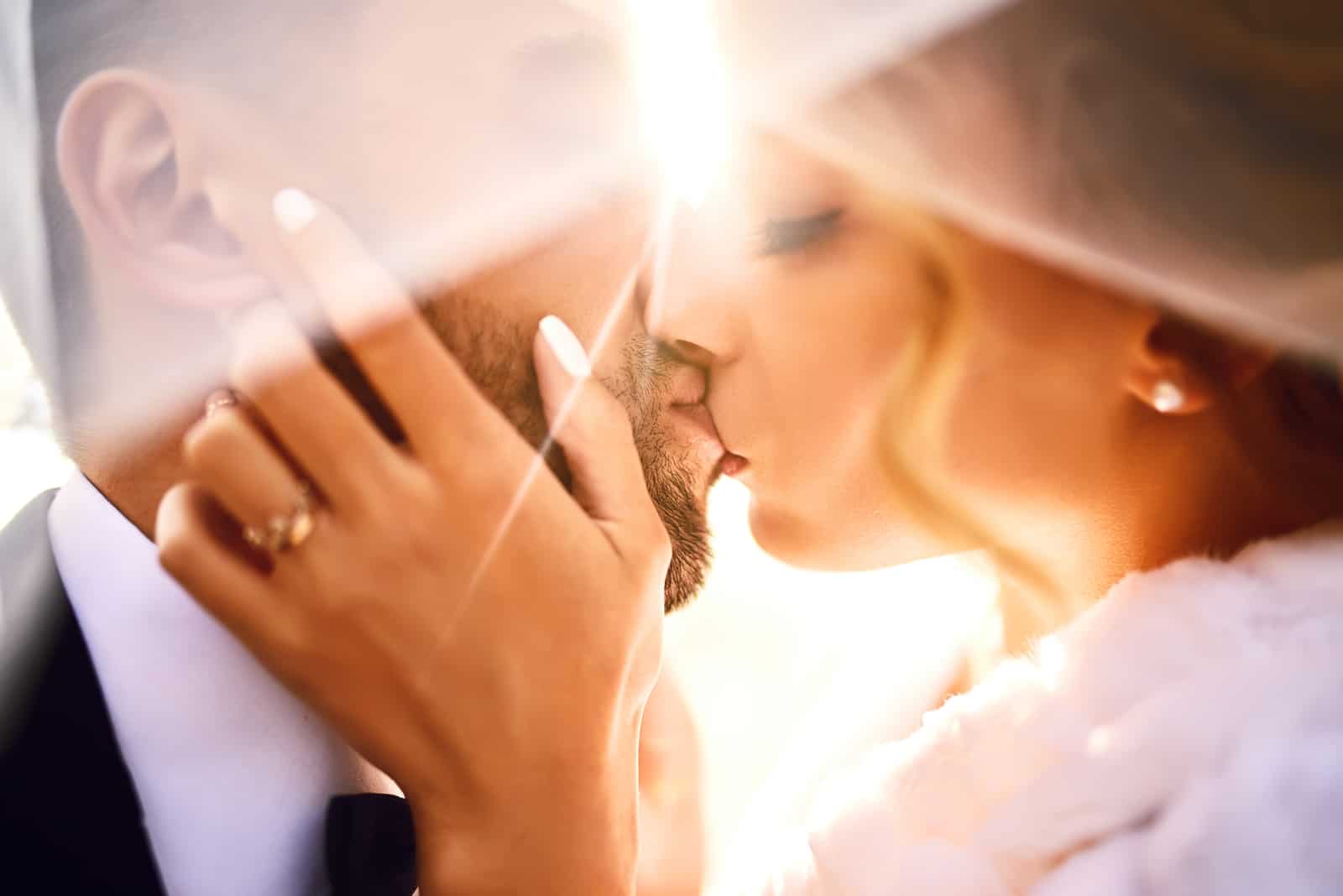 Braut und Bräutigam küssen zärtlich