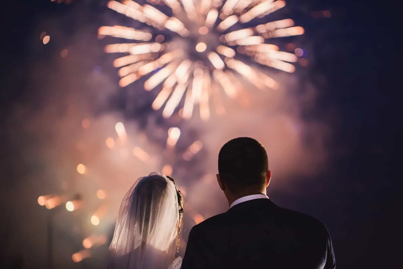 Braut und Bräutigam schauen sich das Feuerwerk an