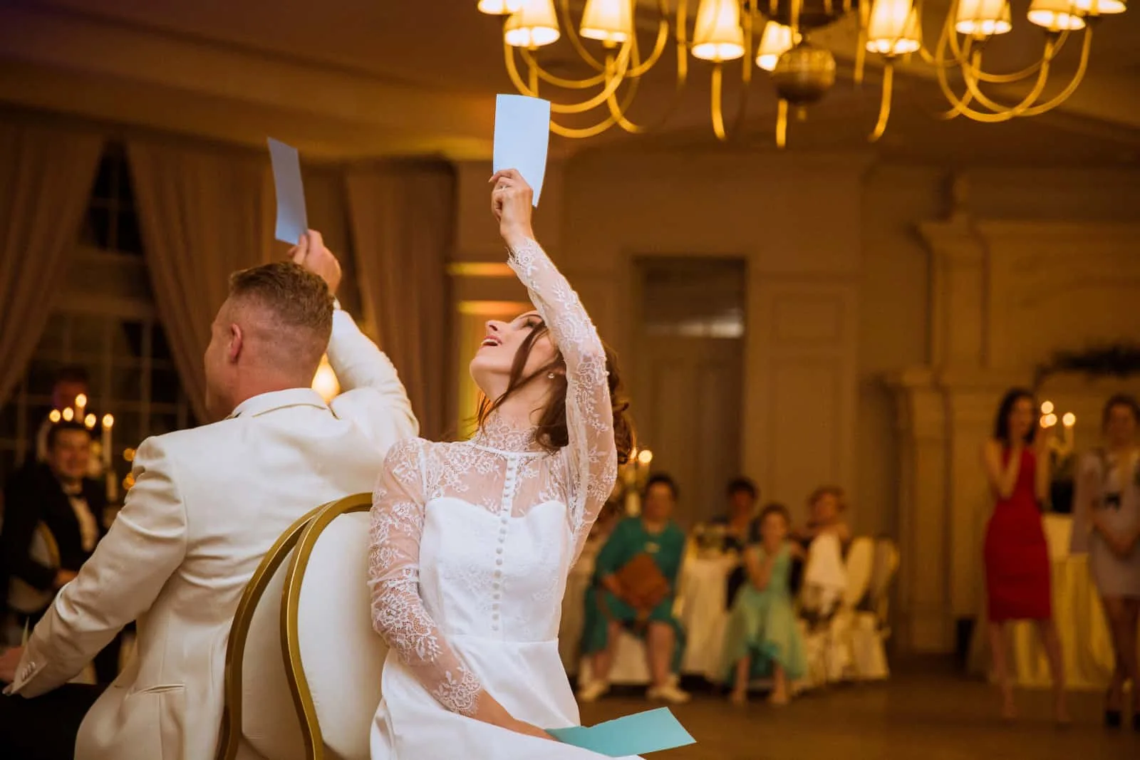 Braut und Bräutigam sitzen auf Stühlen mit Papieren in der Luft