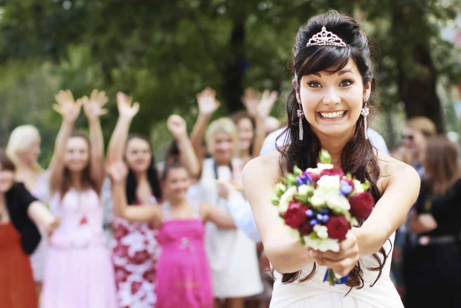 Braut werfen Blumenstrauß für Gäste zu fangen