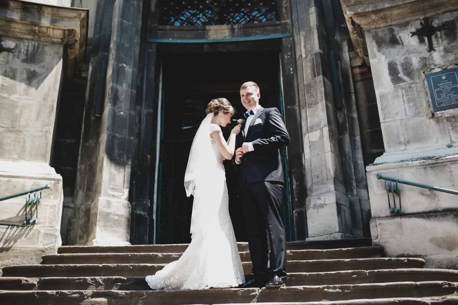 Brautpaar steht auf den Stufen der Kirche