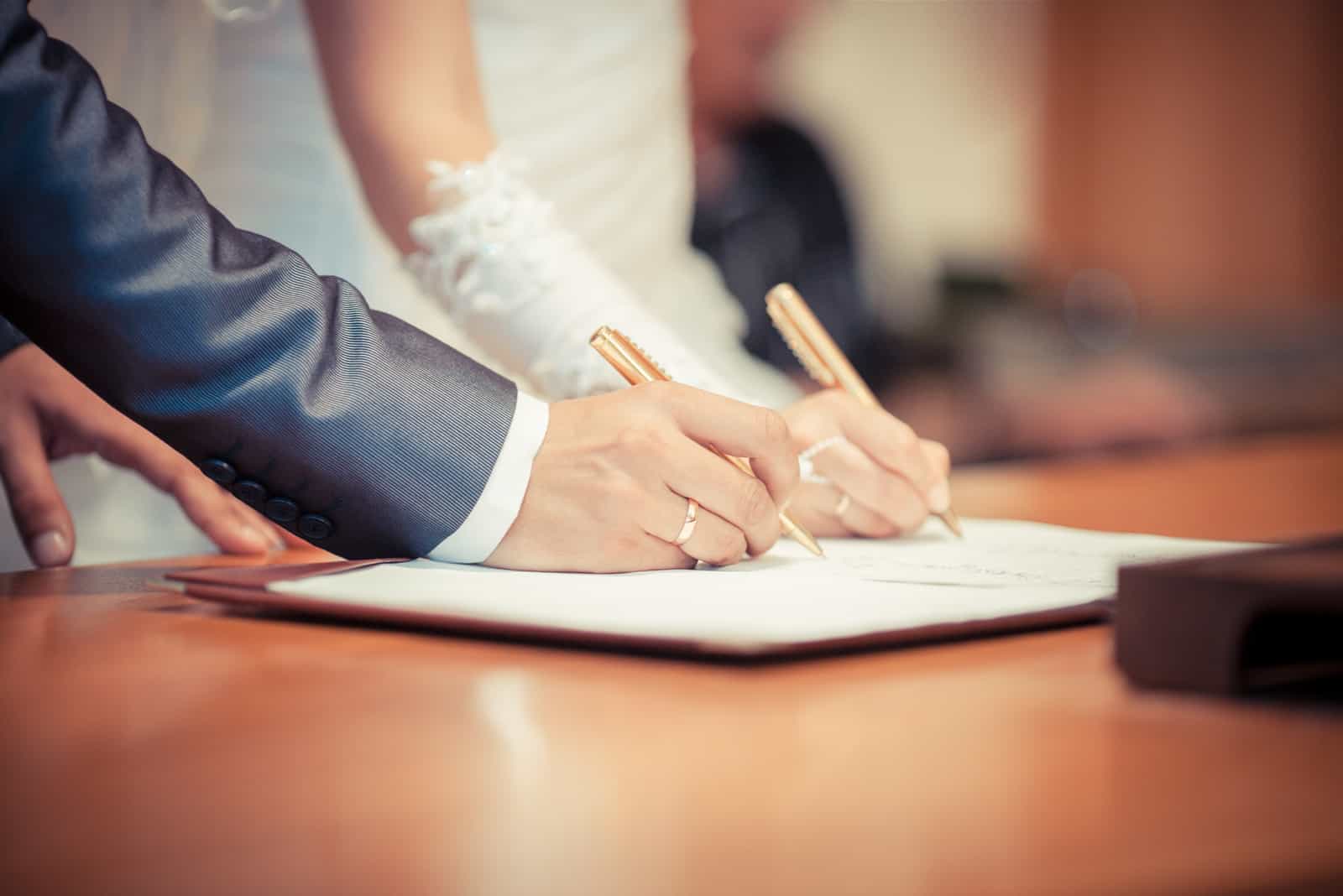 Das Brautpaar unterschreibt die Ehe