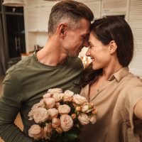glückliches kaukasisches Paar, das selfie Foto mit Blumen nimmt