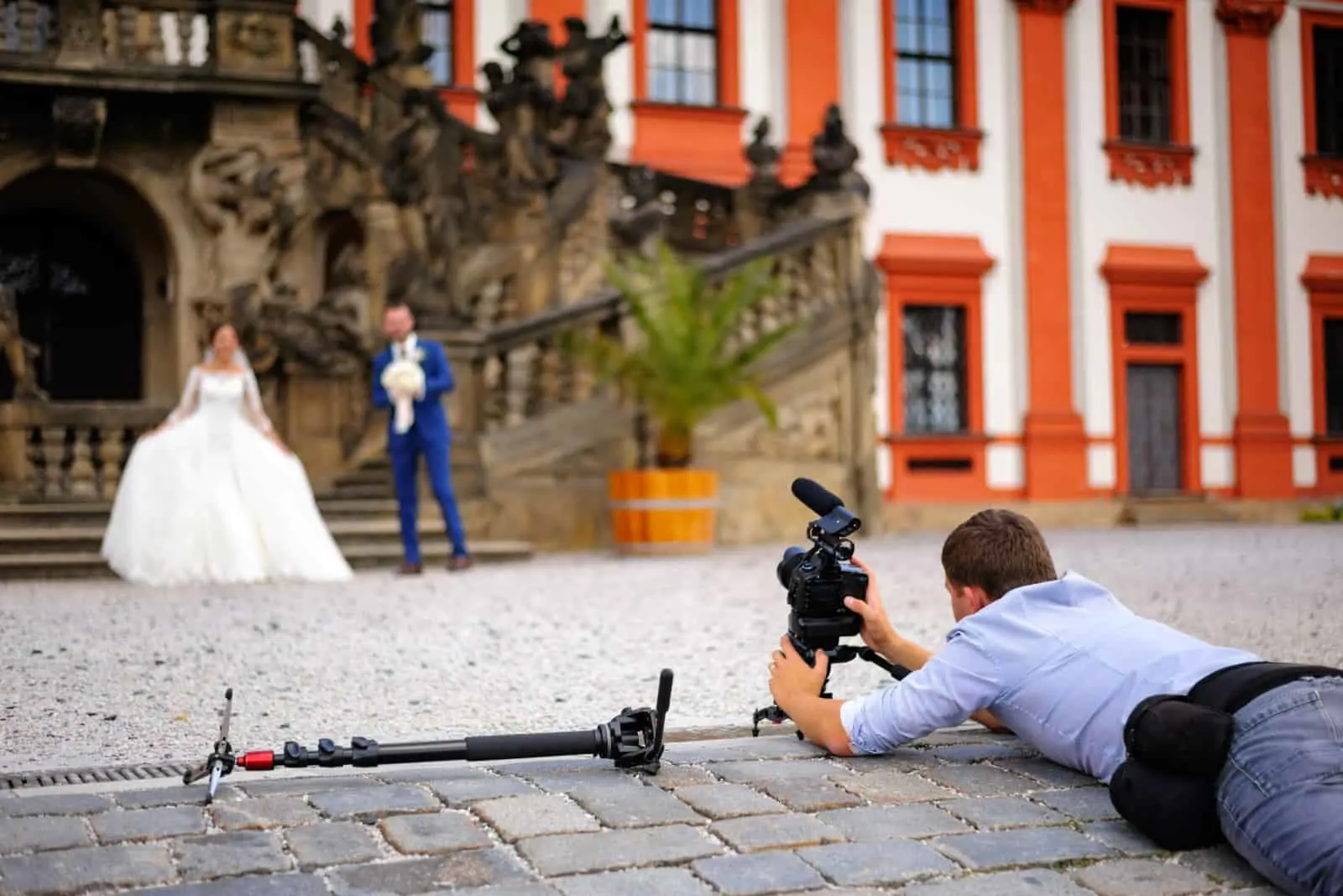 Ein Kameramann liegt auf dem Boden, um das Brautpaar zu filmen