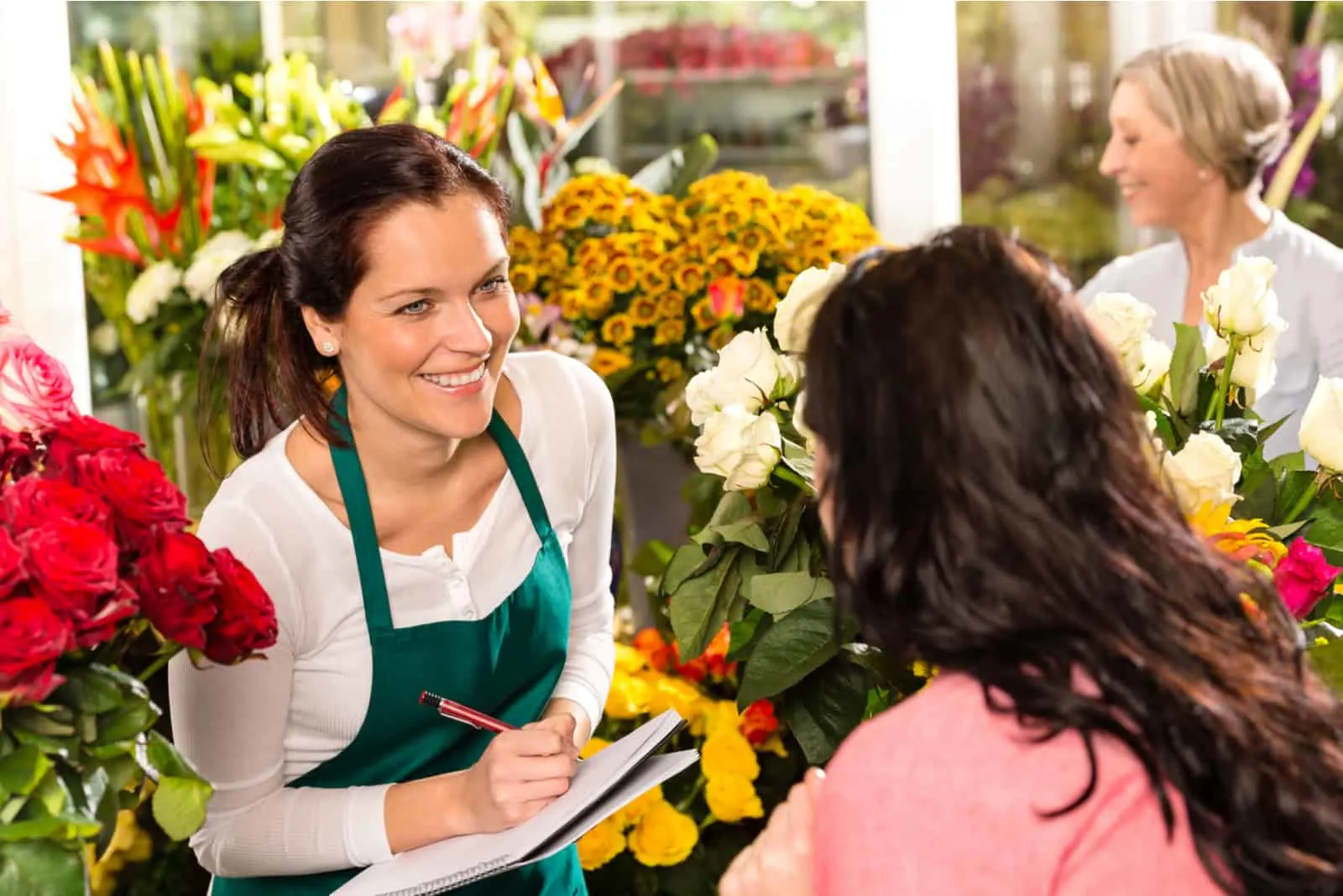 Ein lächelnder Florist spricht mit dem Kunden