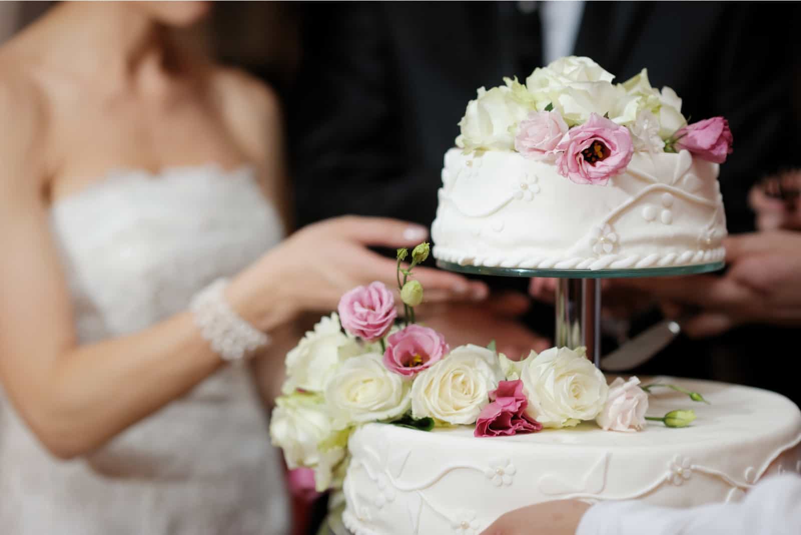 Eine Braut und ein Bräutigam schneiden ihre Hochzeitstorte