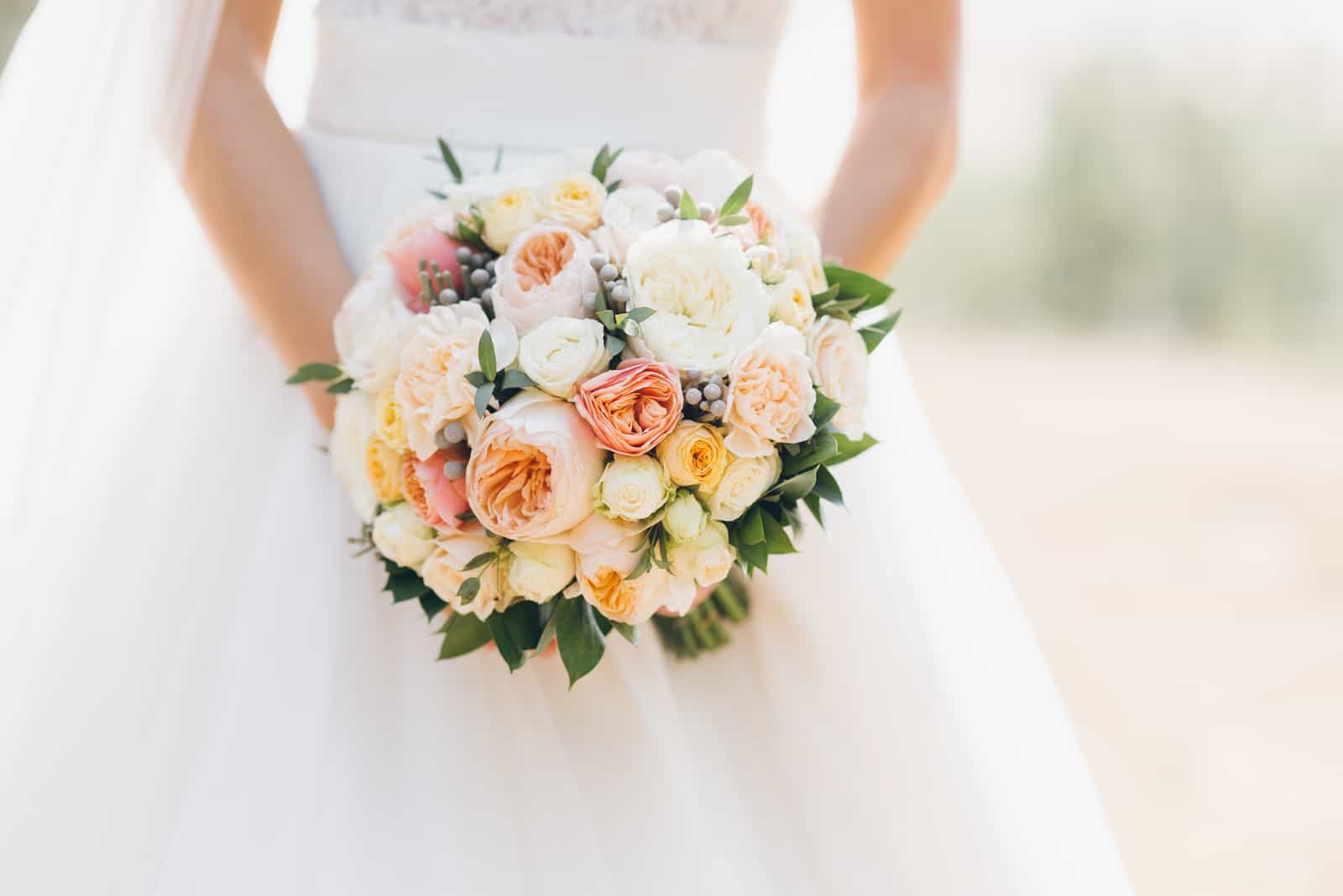 Hochzeitsblumen in den Händen der Braut