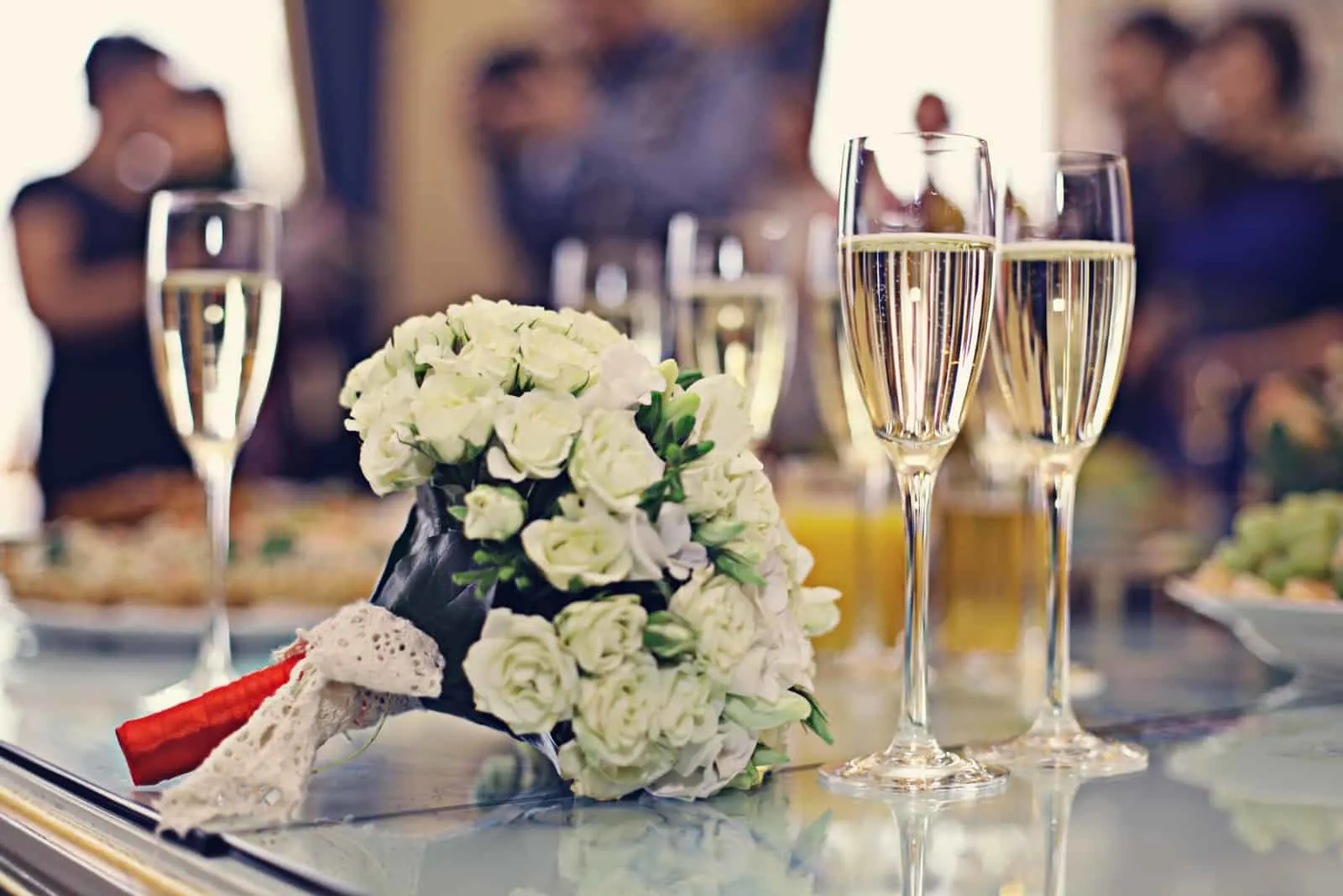 Hochzeitsstrauß und Champagner auf dem Tisch