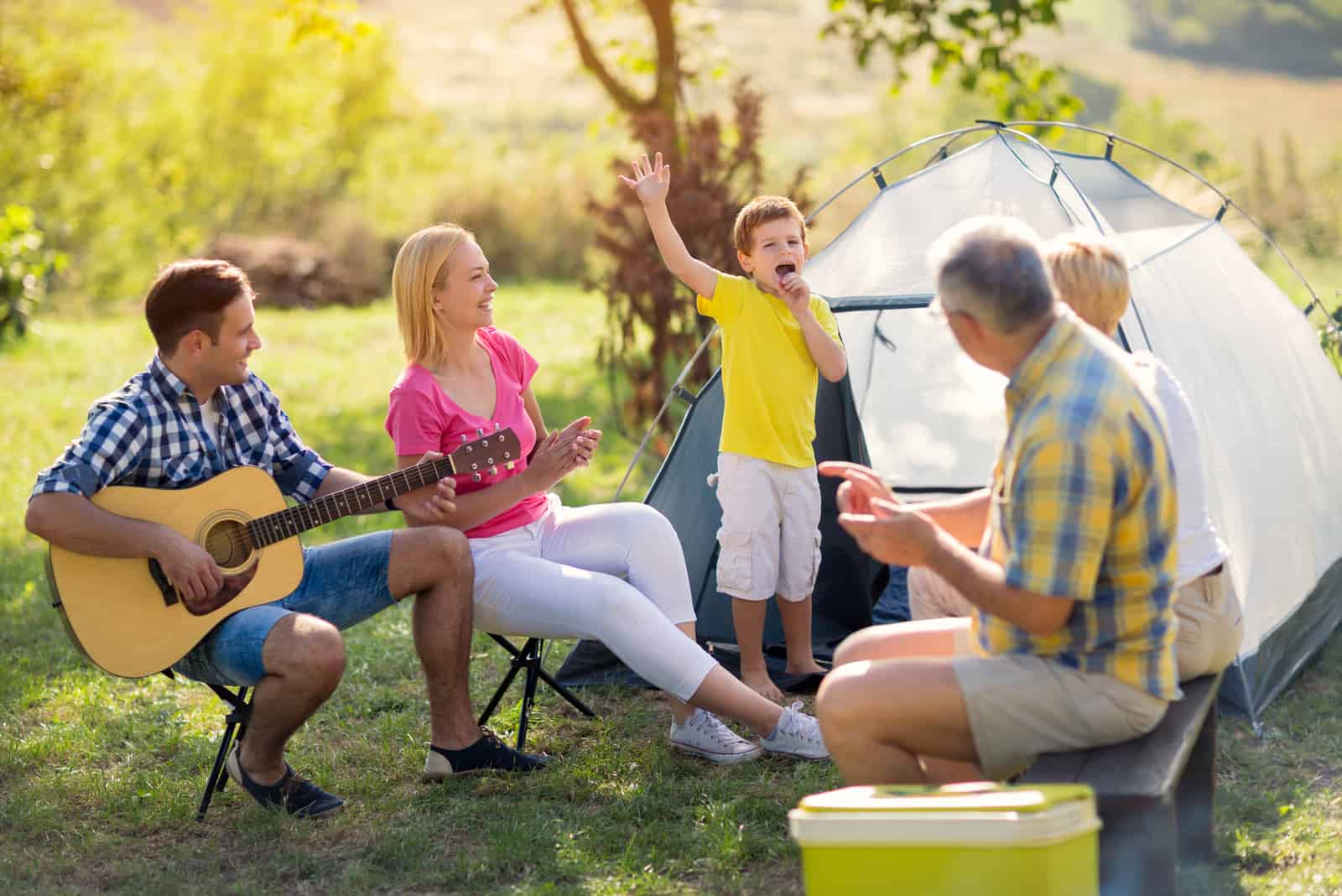 Kind singt mit der Familie auf dem Campingplatz