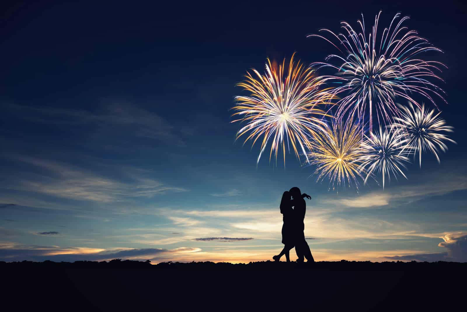Mann und Frau im Natursonnenuntergang, Feuerwerkshintergrund