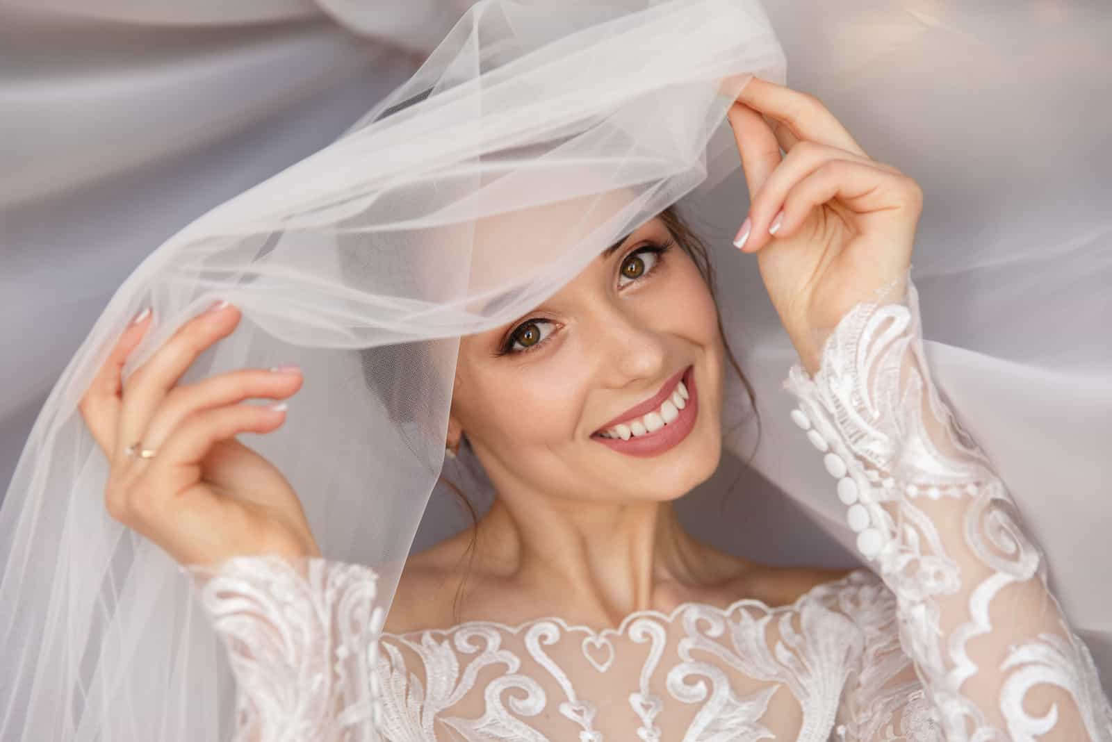 Schöne Braut mit Hochzeits-Make-up im weißen Hochzeitsschleier