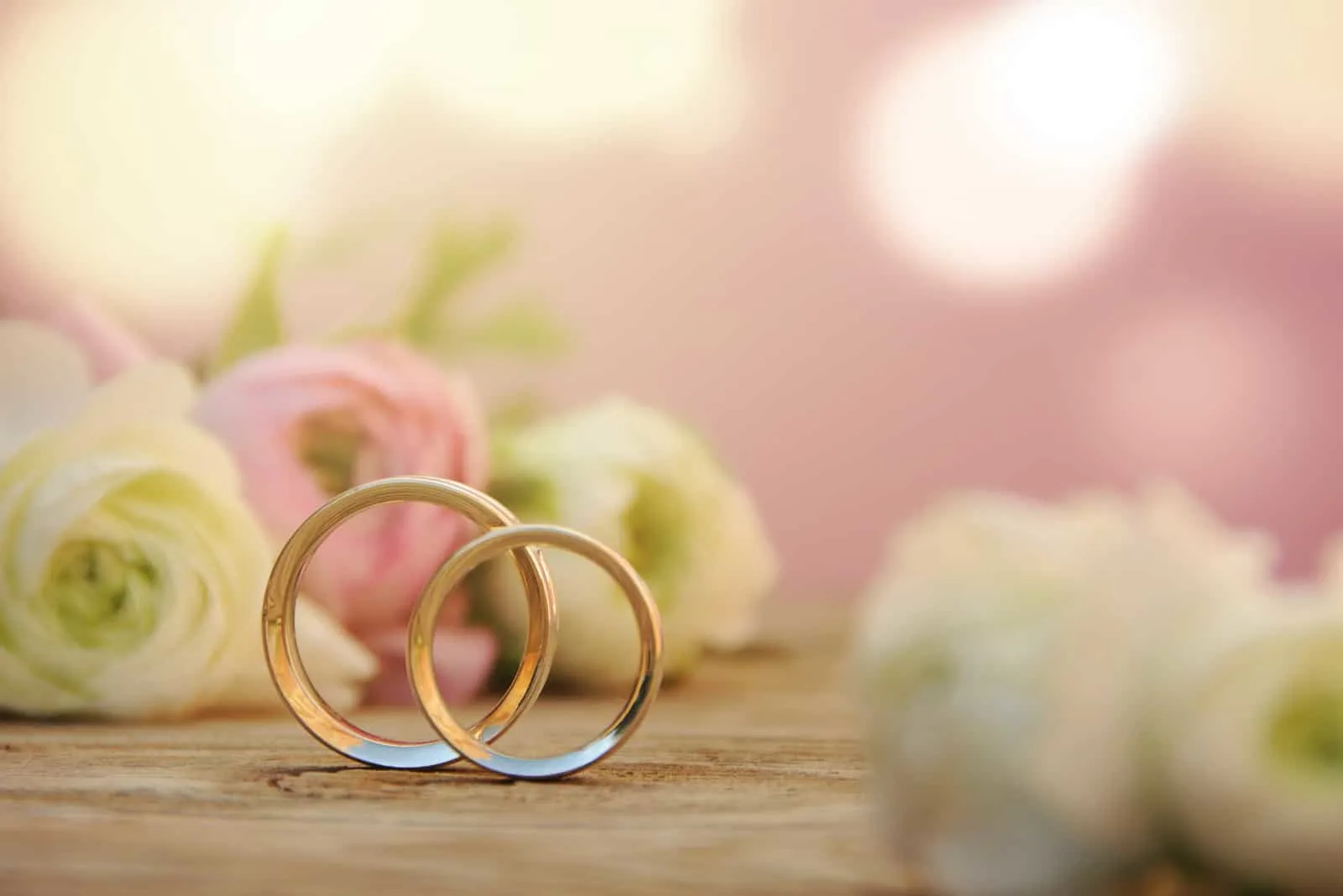 Zarter Hochzeitshintergrund mit Ringen und Butterblumenblume