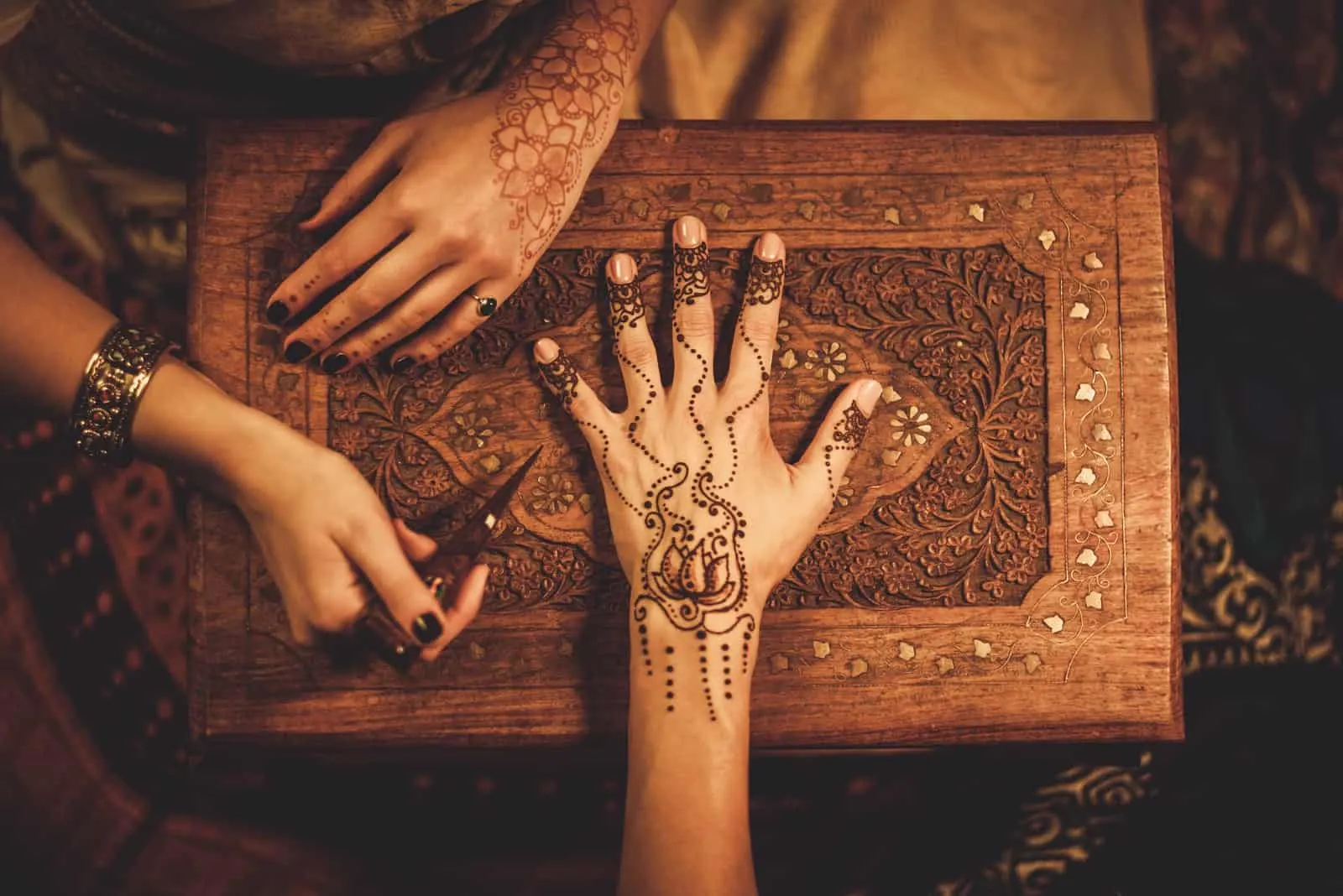 Zeichenprozess der Henna-Menhdi-Verzierung auf der Hand der Frau