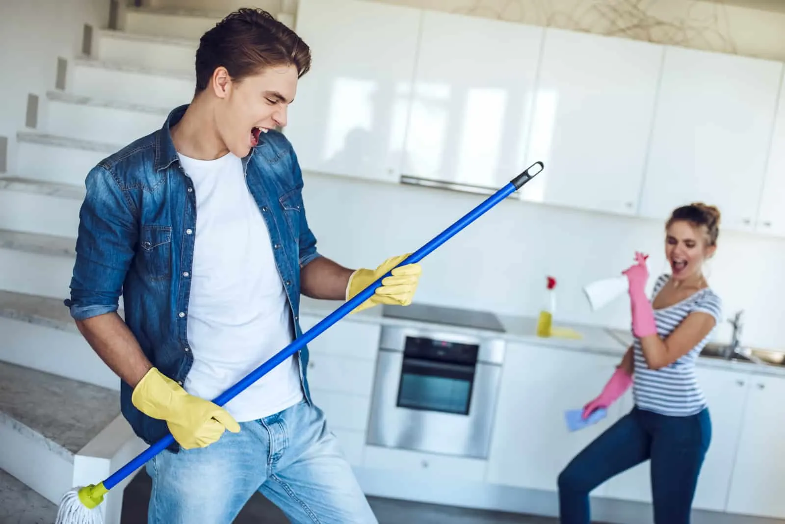 Zwei junge Leute haben Spaß beim Putzen des Hauses
