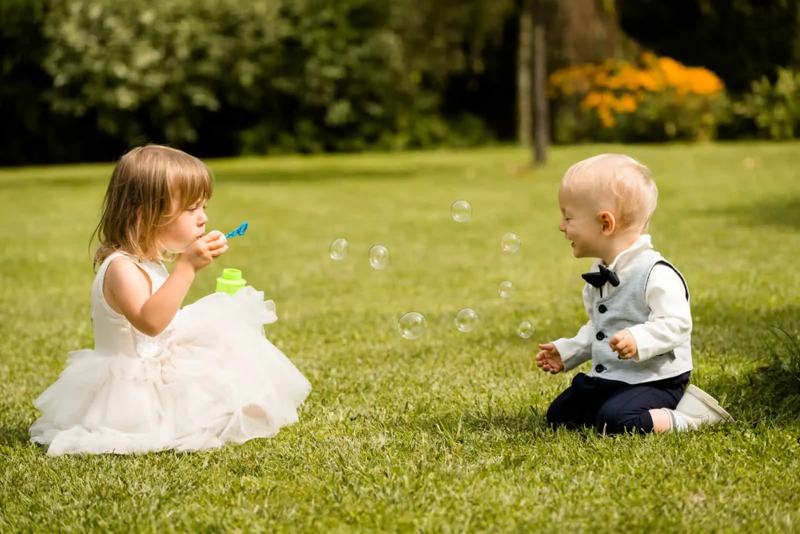Zwei kleine Kinder spielen im Gras