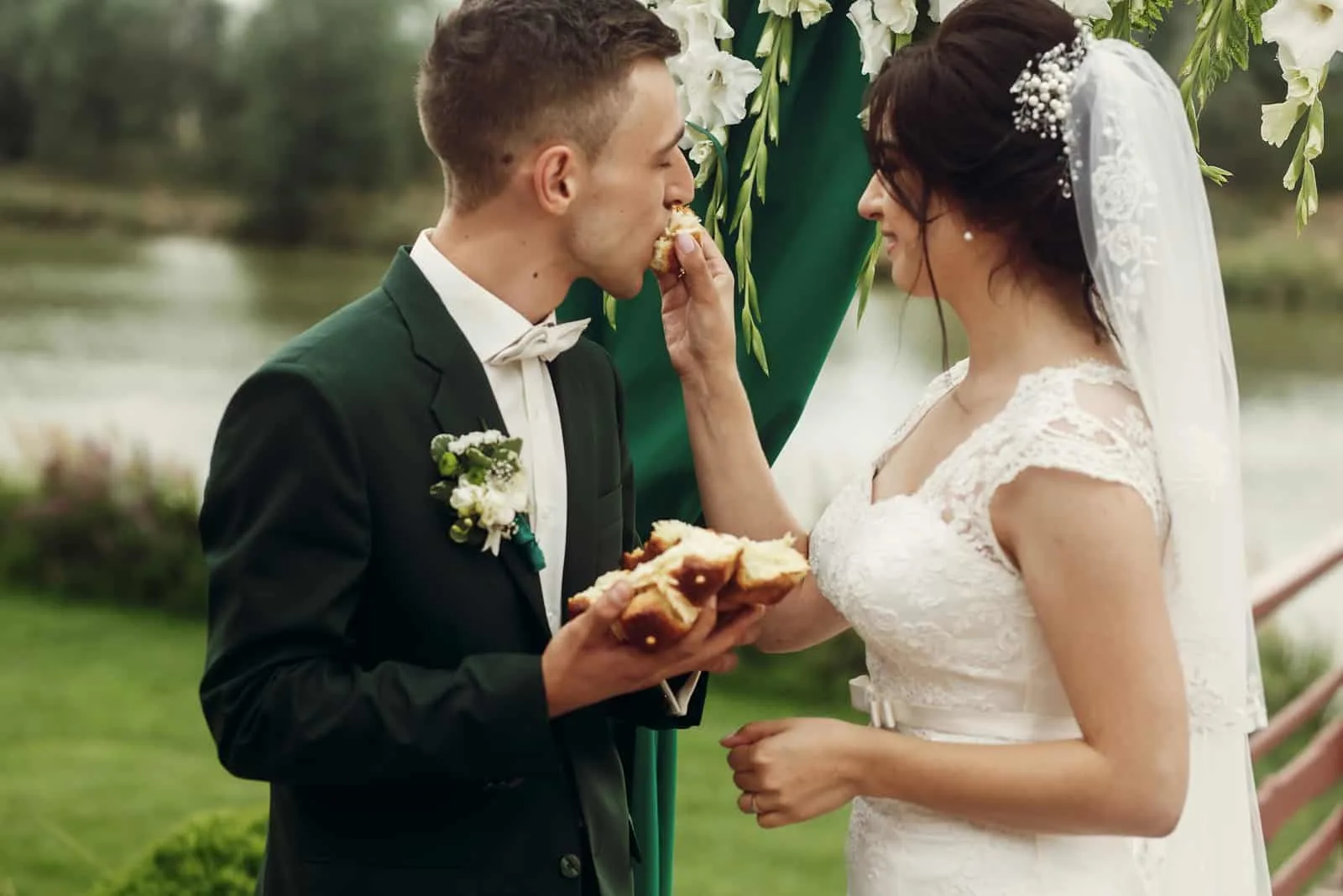 frisch verheiratetes Paar, das Brot bei der Hochzeitszeremonie bricht