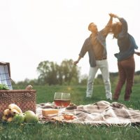 ein liebevolles Paar, das bei einem Picknick in der Natur tanzt