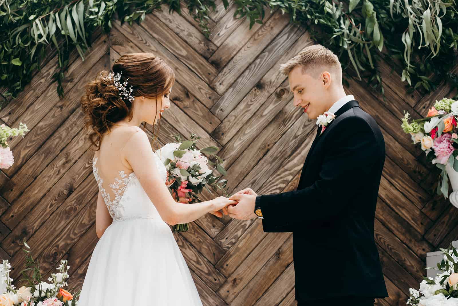 Der Bräutigam legt den Ring auf die Braut