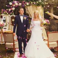 Das Brautpaar wird bei einer Hochzeitszeremonie im Wald mit Konfetti überschüttet
