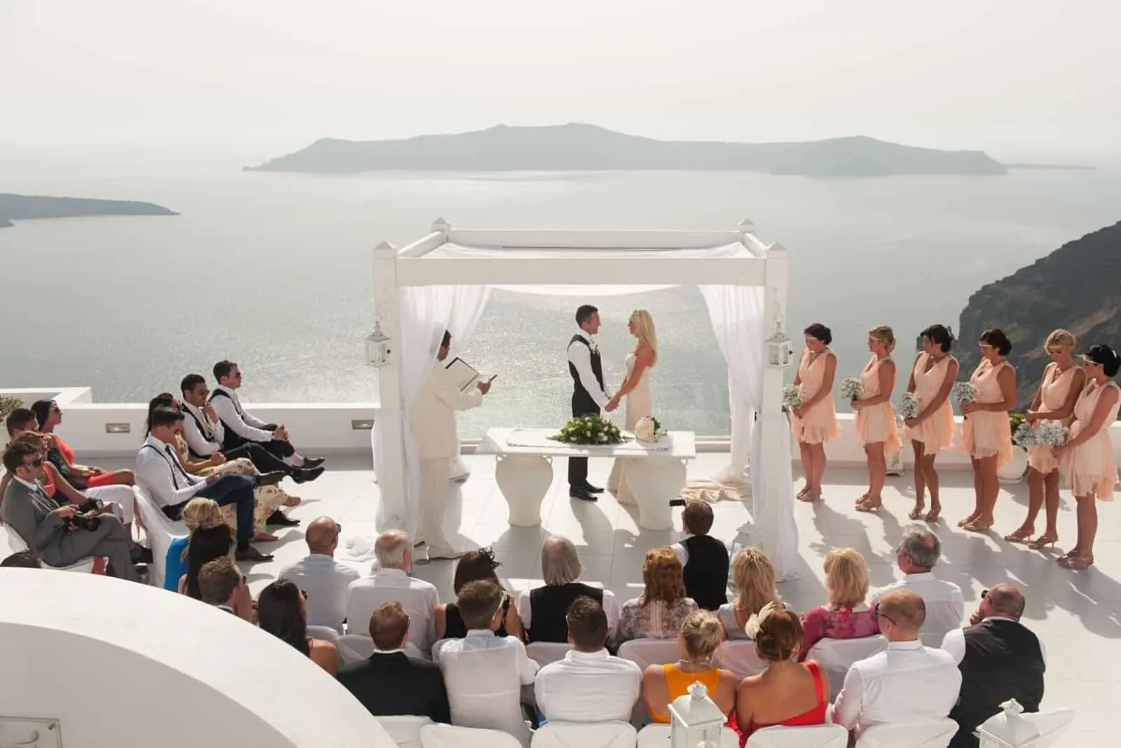 Hochzeit auf einer schönen Terrasse am Meer halten die Jungvermählten Händchen